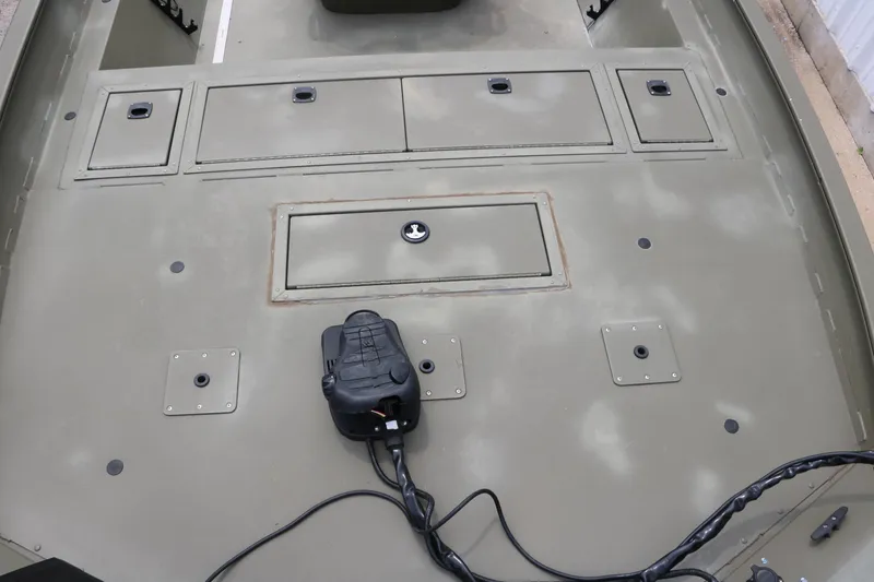 Slide: The Image of 2024 Tracker Grizzly 2072 MVX boat deck with storage compartments and control panel. - 19