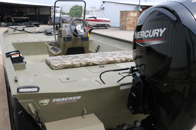 Slide: The Image of 2024 Tracker Grizzly 2072 MVX boat with Mercury engine, featuring spacious interior and camouflage seating. - 26