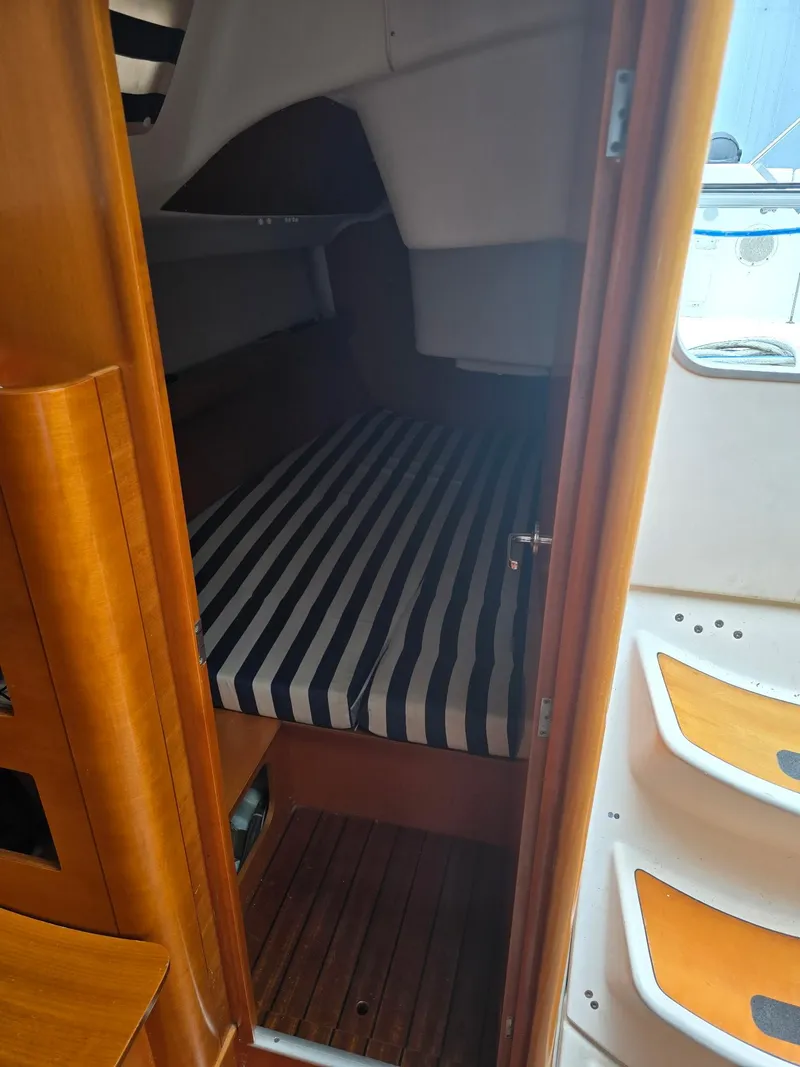 Slide: The Image of Cozy cabin interior of 2000 Beneteau First 40.7 sailboat with striped bedding. - 13