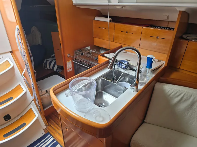 Slide: The Image of Interior of 2000 Beneteau First 40.7 yacht, featuring a compact kitchen area. - 16