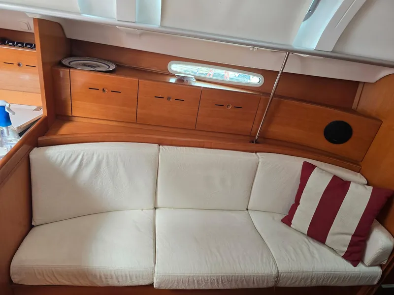 Slide: The Image of Interior of 2000 Beneteau First 40.7 yacht with white sofa and striped pillow. - 18