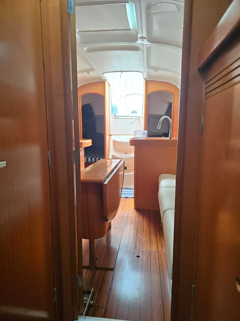 Slide: The Image of Interior of 2000 Beneteau First 40.7 sailboat, featuring wooden cabinetry and seating area. - 24