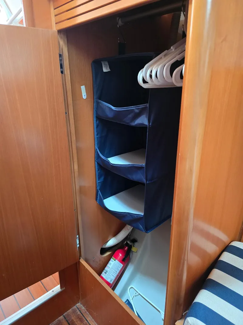 Slide: The Image of Wooden closet with hanging organizer and fire extinguisher in 2000 Beneteau First 40.7 sailboat. - 26