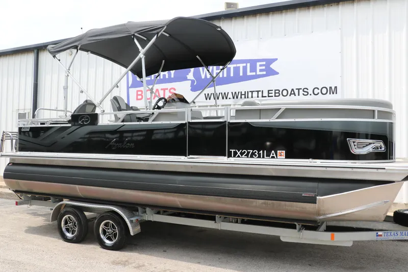 The Image of 2023 Avalon Venture 2385 RF pontoon boat on trailer, parked outside dealership. - 1