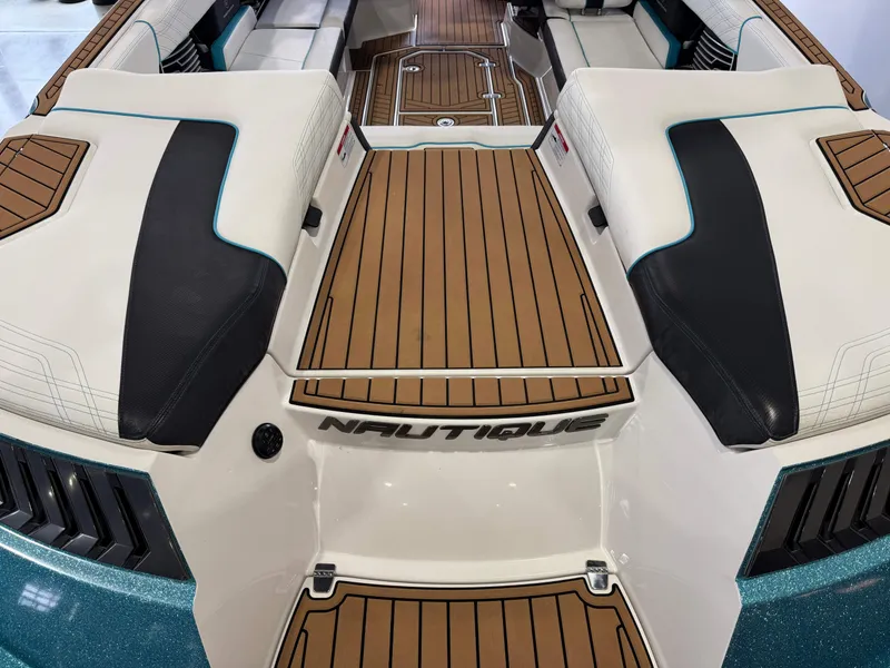 Slide: The Image of 2019 Nautique Super Air Nautique G25 boat interior with teak flooring and cushioned seating. - 10