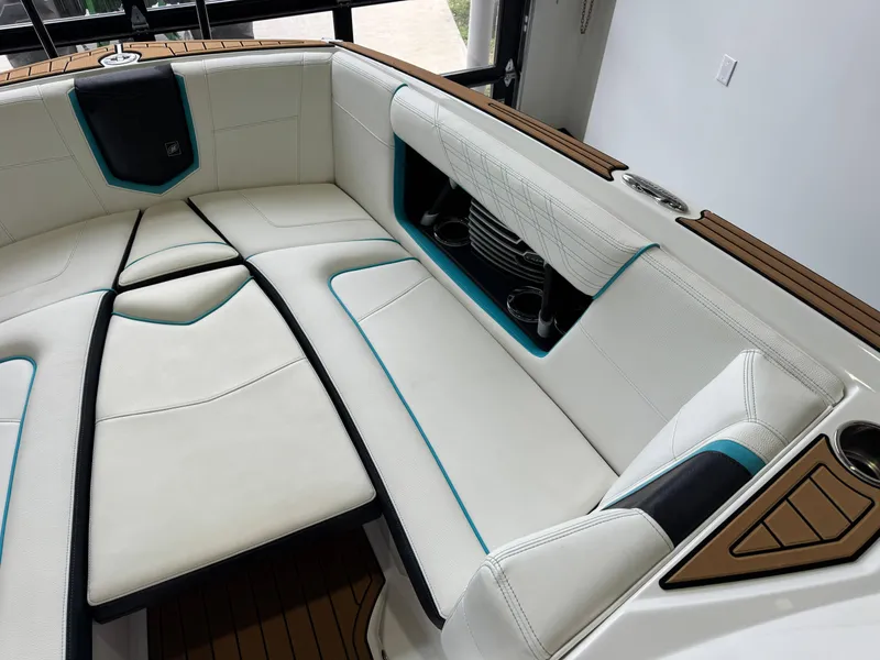 Slide: The Image of 2019 Nautique Super Air Nautique G25 interior with white seating and teal accents. - 18