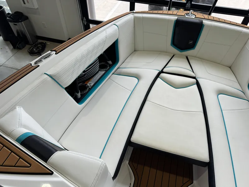Slide: The Image of 2019 Nautique Super Air Nautique G25 interior with white seating and teal accents. - 19