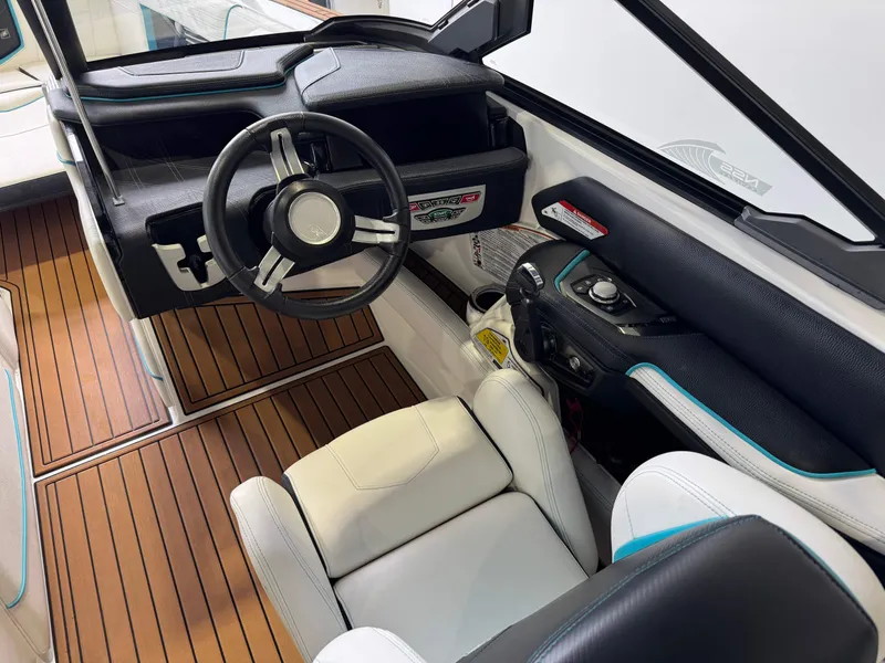 Slide: The Image of 2019 Nautique Super Air Nautique G25 boat interior with steering wheel and seating. - 25