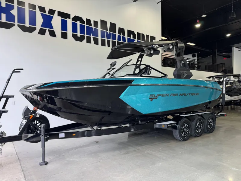 Slide: The Image of 2019 Nautique Super Air Nautique G25 boat in showroom, black and teal design. - 3