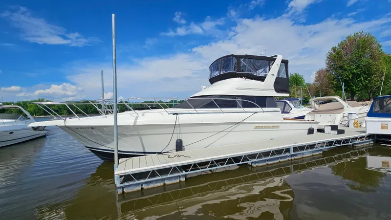 The Image of 1995 Silverton 41 Convertible yacht docked on a sunny day, featuring sleek design and spacious deck. - 1
