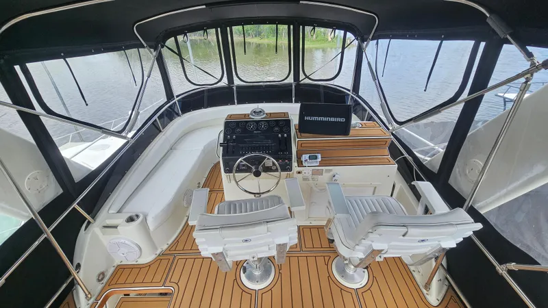 Slide: The Image of 1995 Silverton 41 Convertible yacht cockpit with dual seats and wooden flooring. - 14