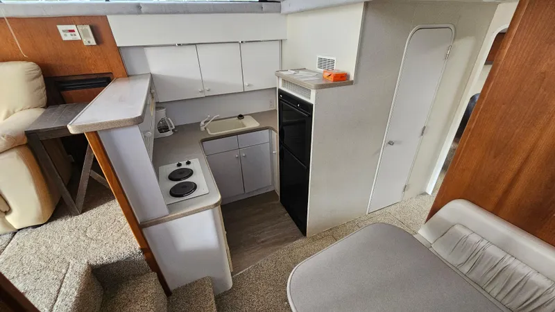 Slide: The Image of Interior of 1995 Silverton 41 Convertible yacht, featuring compact kitchen and seating area. - 19