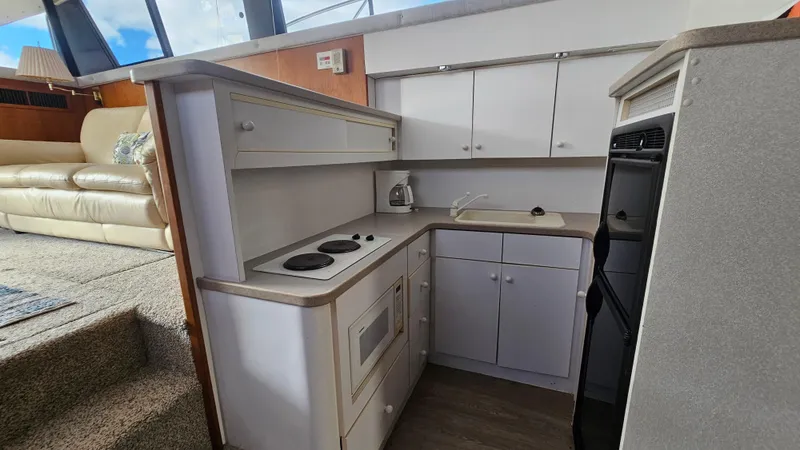 Slide: The Image of 1995 Silverton 41 Convertible yacht kitchen with stove, microwave, and cabinets. - 20