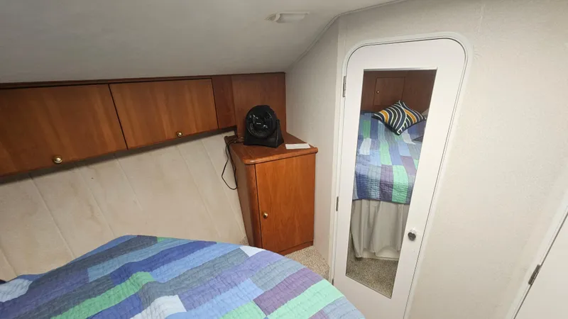 Slide: The Image of 1995 Silverton 41 Convertible cabin interior with colorful bedding and wooden cabinets. - 25