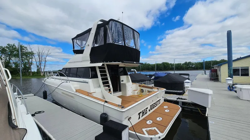 Slide: The Image of 1995 Silverton 41 Convertible yacht docked under a partly cloudy sky. - 33