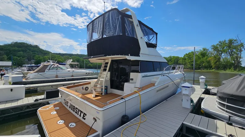 Slide: The Image of 1995 Silverton 41 Convertible yacht docked at a marina under a clear blue sky. - 4