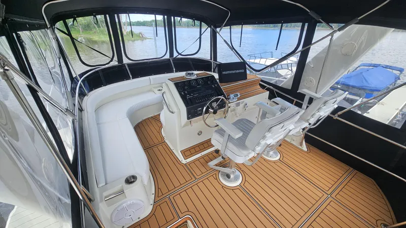 Slide: The Image of 1995 Silverton 41 Convertible boat interior with helm, seating, and wood flooring. - 8