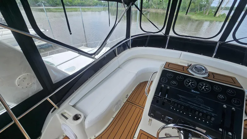 Slide: The Image of 1995 Silverton 41 Convertible yacht helm with wood accents and river view. - 9