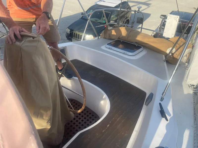 Slide: The Image of Man steering a 1984 Hanseat 37 sailboat with wooden deck and covered wheel. - 11