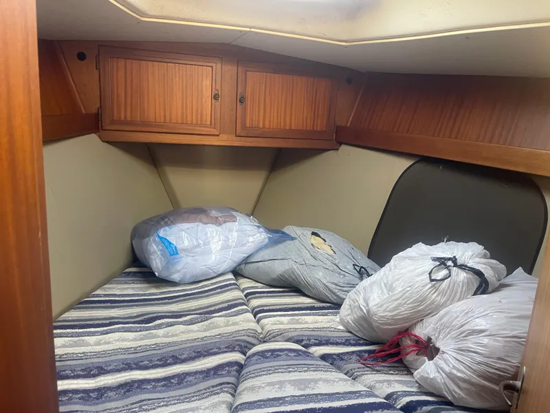 Slide: The Image of Cabin interior of 1984 Hanseat 37 sailboat with striped bedding and storage bags. - 16
