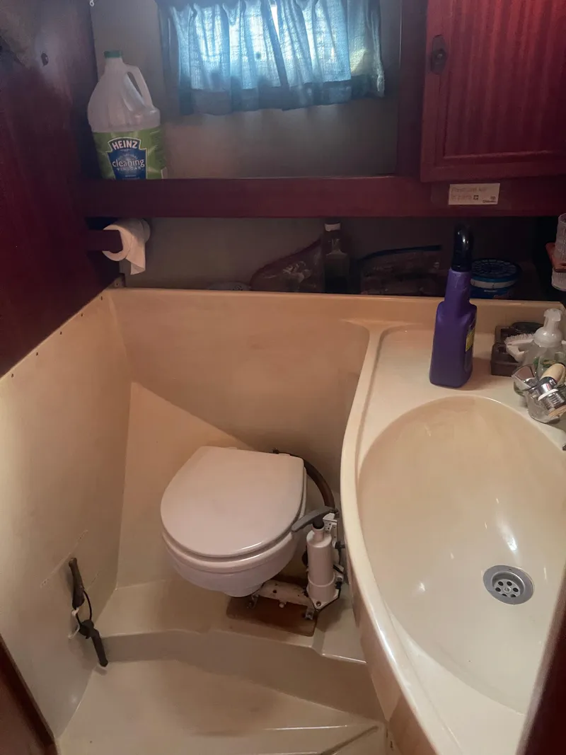 Slide: The Image of Compact bathroom in a 1984 Hanseat 37 sailboat, featuring a toilet and sink. - 18