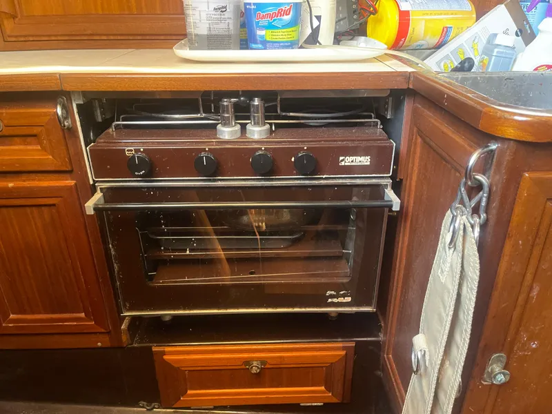 Slide: The Image of Vintage 1984 Hanseat 37 boat kitchen with a compact brown oven and wooden cabinetry. - 24