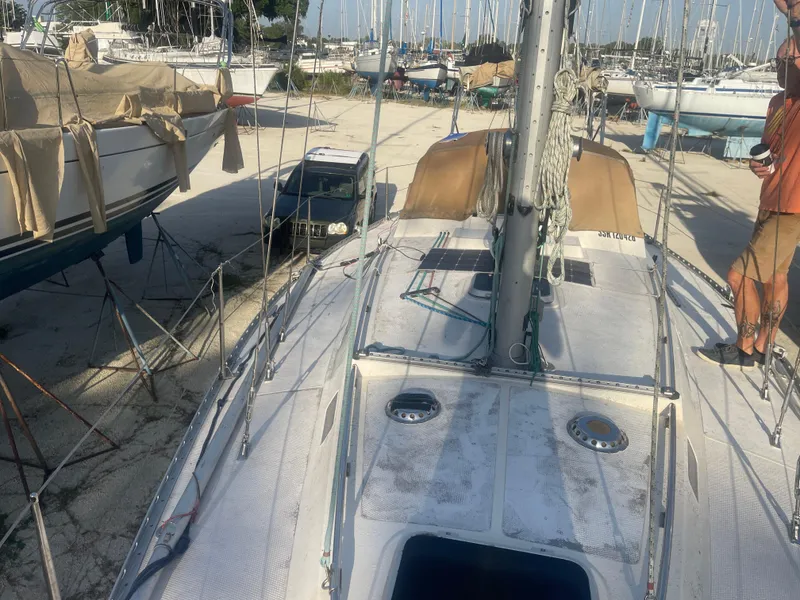 Slide: The Image of 1984 Hanseat 37 sailboat on dry dock, surrounded by other boats and equipment. - 7