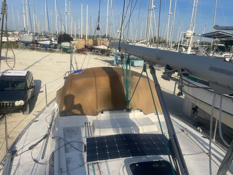 Slide: The Image of 1984 Hanseat 37 sailboat on land with solar panel and parked car nearby. - 9
