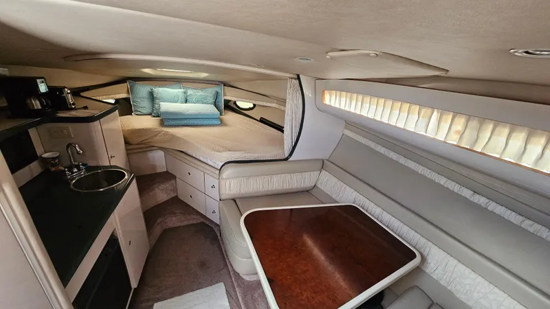 Slide: The Image of 1995 Regal Commodore 292 cabin interior with bed, kitchenette, and dining area. - 16