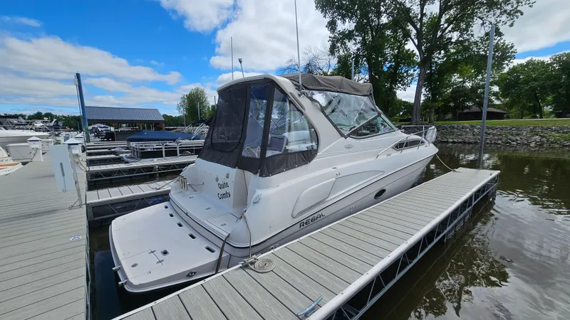 Slide: The Image of 1995 Regal Commodore 292 boat docked at marina under blue sky. - 2