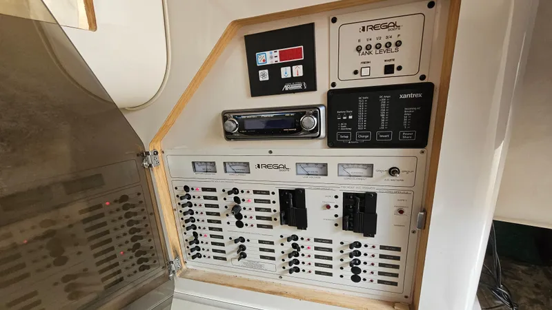 Slide: The Image of Control panel of a 1995 Regal Commodore 292 boat, featuring various switches and gauges. - 26