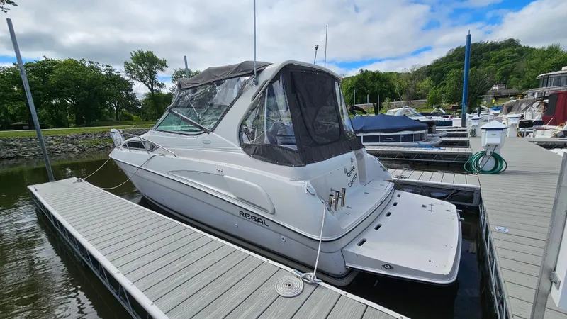 Slide: The Image of 1995 Regal Commodore 292 boat docked at marina under cloudy sky. - 3