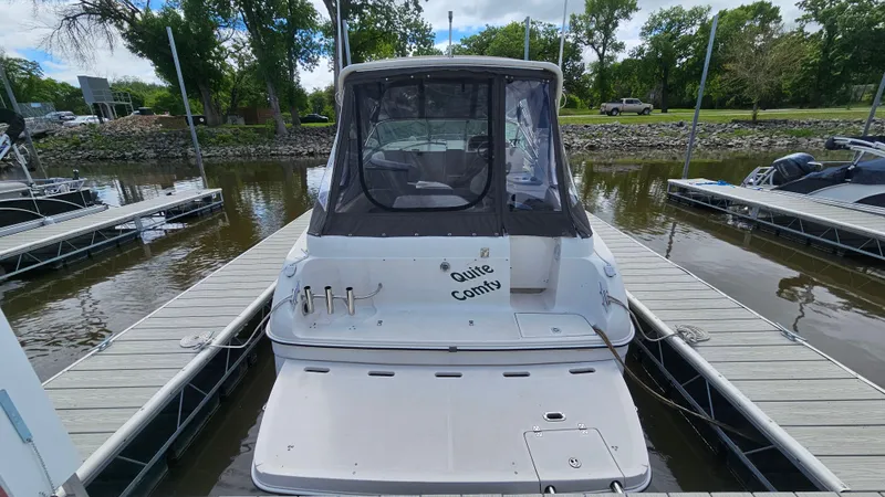 Slide: The Image of 1995 Regal Commodore 292 boat docked at marina, rear view with canopy and calm water. - 5