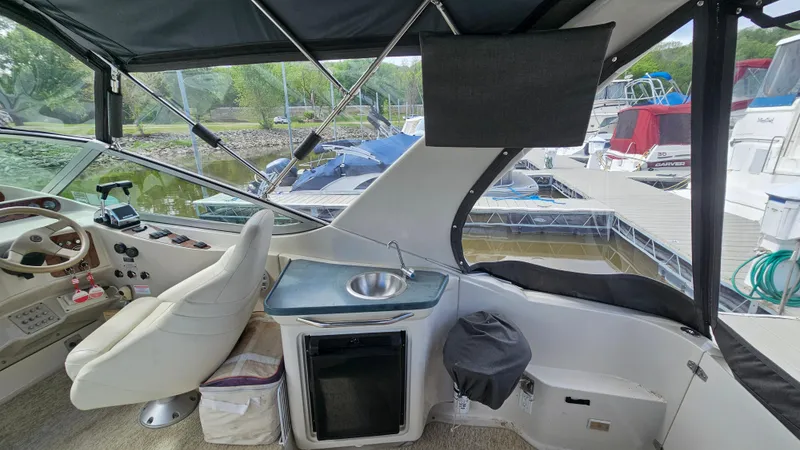 Slide: The Image of Interior of 1995 Regal Commodore 292 boat with helm, sink, and docked marina view. - 9