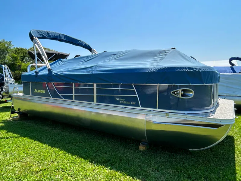Slide: The Image of 2023 Landau Island Breeze 232 Cruise pontoon boat with blue cover on grass. - 9