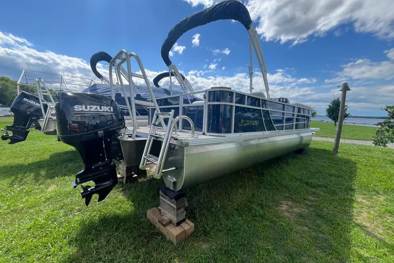 Slide: The Image of 2025 Landau Island Breeze 232 Cruise pontoon boat with Suzuki outboard motor on grassy shore. - 12