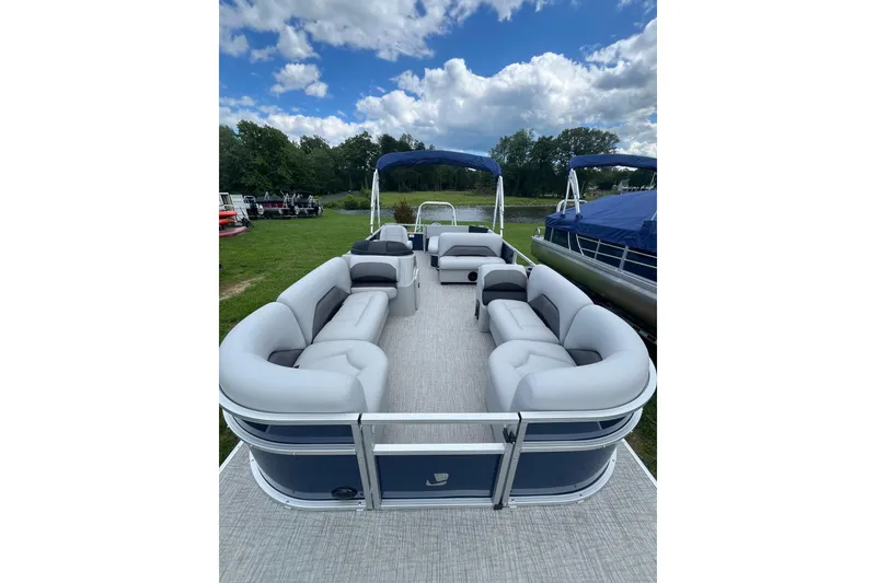 Slide: The Image of 2025 Landau Island Breeze 232 Cruise pontoon boat with spacious seating and blue canopy. - 6