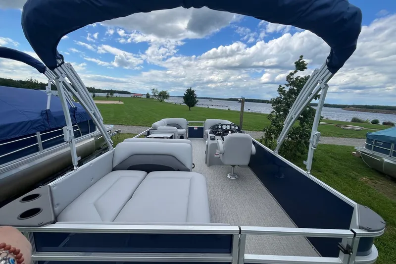 Slide: The Image of 2025 Landau Island Breeze 232 Cruise pontoon boat with spacious seating and scenic lake view. - 7