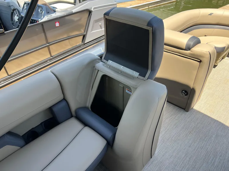 Slide: The Image of 2025 Starcraft EXS 3 Q DH boat interior with open storage compartment and beige seating. - 12