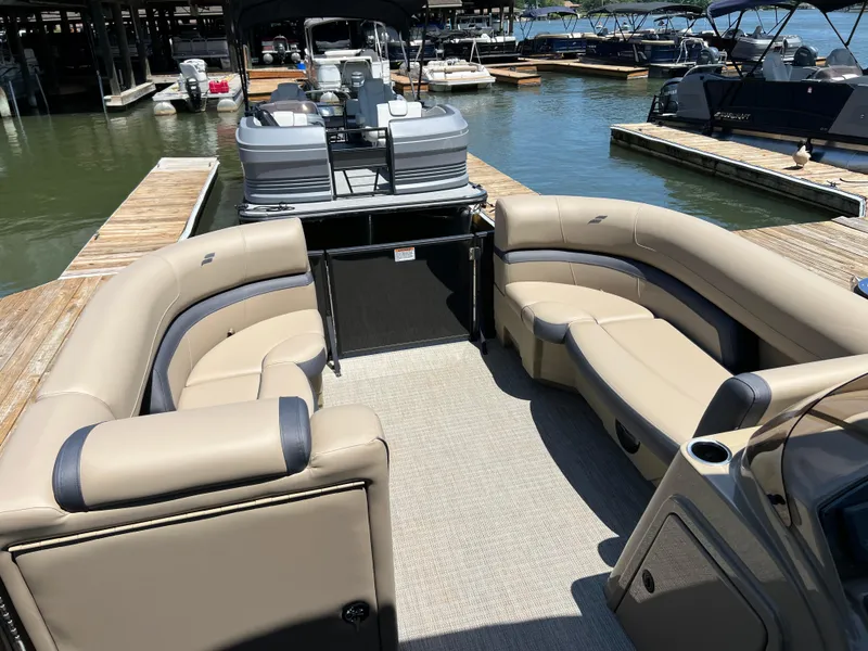 Slide: The Image of Luxurious 2025 Starcraft EXS 3 Q DH pontoon boat with spacious seating at a marina. - 3