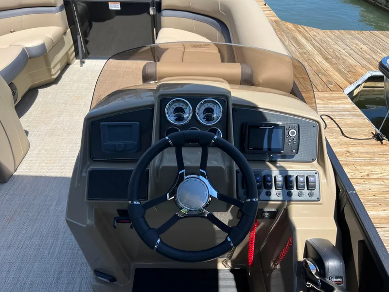 Slide: The Image of 2025 Starcraft EXS 3 Q DH boat dashboard with steering wheel and control panel. - 4