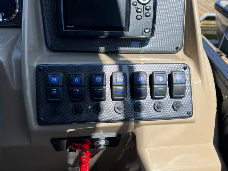 Slide: The Image of Control panel of 2025 Starcraft EXS 3 Q DH boat with switches and display screen. - 7