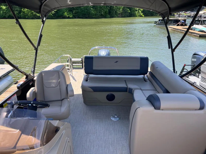 Slide: The Image of 2025 Starcraft EXS 3 Q DH boat interior with seating, on a calm lake. - 8