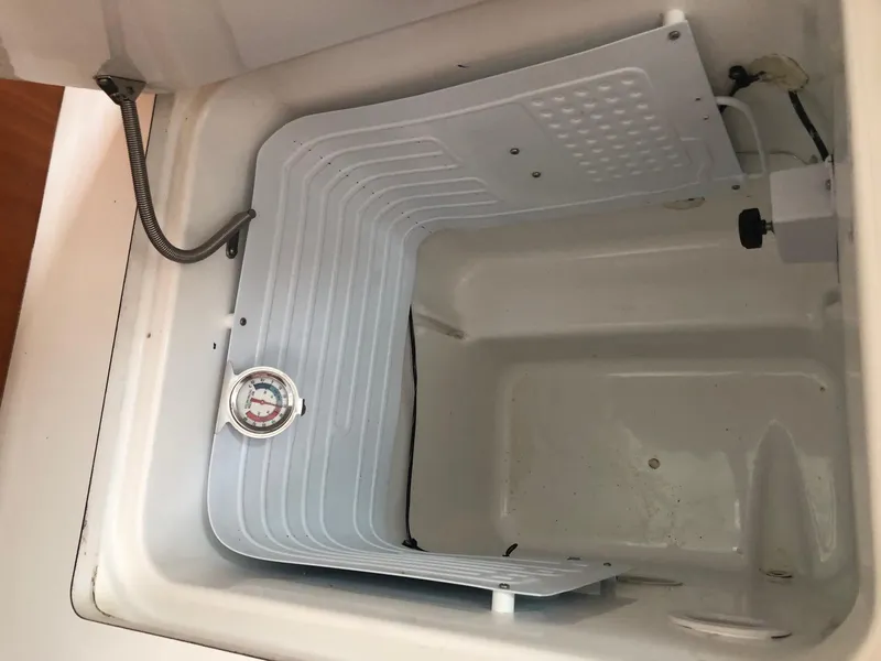 Slide: The Image of Interior of a 2001 Beneteau 361 boat showing a compartment with a thermometer. - 10