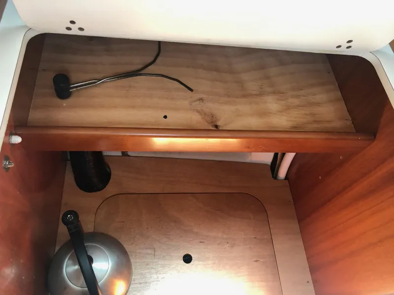 Slide: The Image of Interior storage compartment of a 2001 Beneteau 361 sailboat, featuring wooden shelves and a kettle. - 11