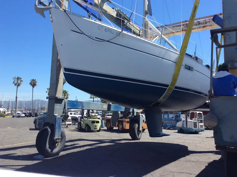 Slide: The Image of 2001 Beneteau 361 sailboat lifted in a marina with palm trees in the background. - 29