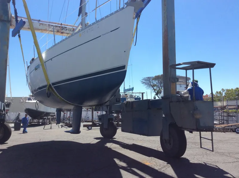 Slide: The Image of 2001 Beneteau 361 sailboat being lifted by a crane in a shipyard. - 30