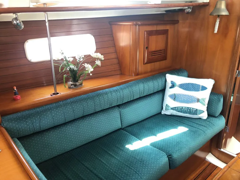 Slide: The Image of Cozy interior of 2001 Beneteau 361 sailboat with teal sofa and decorative pillow. - 5