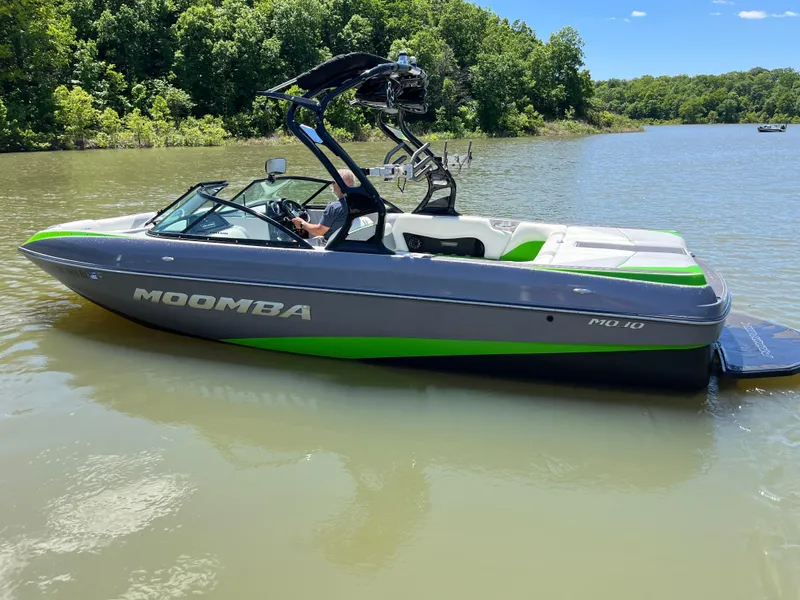 Slide: The Image of 2016 Moomba Mojo boat on a lake, featuring sleek gray and green design. - 0