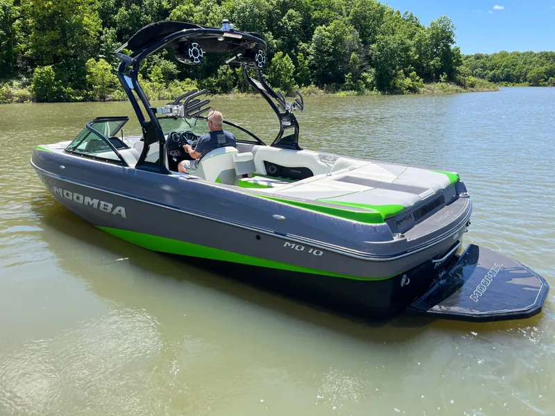 Slide: The Image of 2016 Moomba Mojo boat on a lake, featuring sleek design and vibrant green accents. - 1